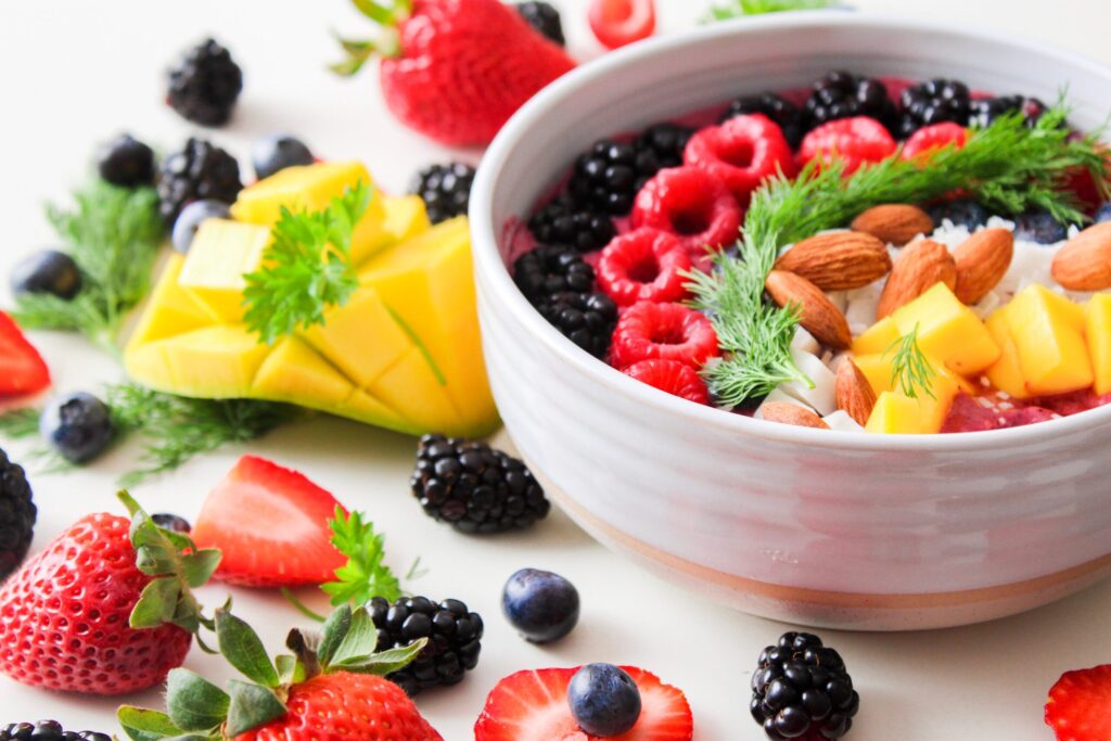Gut Health Moved from Trend to Science A vibrant bowl filled with fresh berries, mango, almonds, and herbs, perfect for a healthy snack or breakfast.
