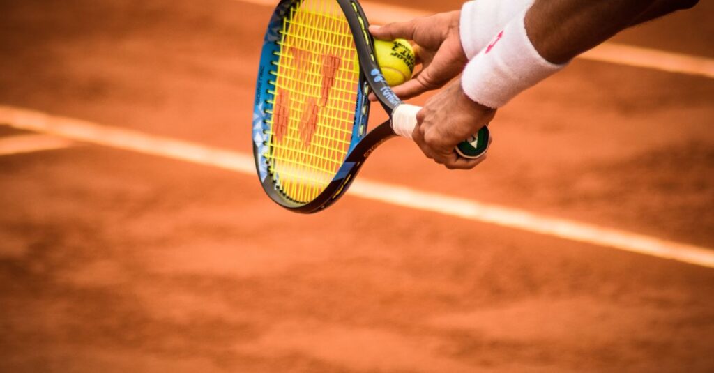 Close-up of a tennis player preparing to serve on a clay court in Montevideo.