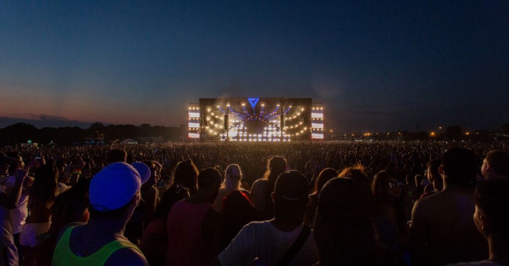 Coachella A large audience enjoys a vibrant outdoor concert at twilight, showcasing dazzling stage lights and performers.