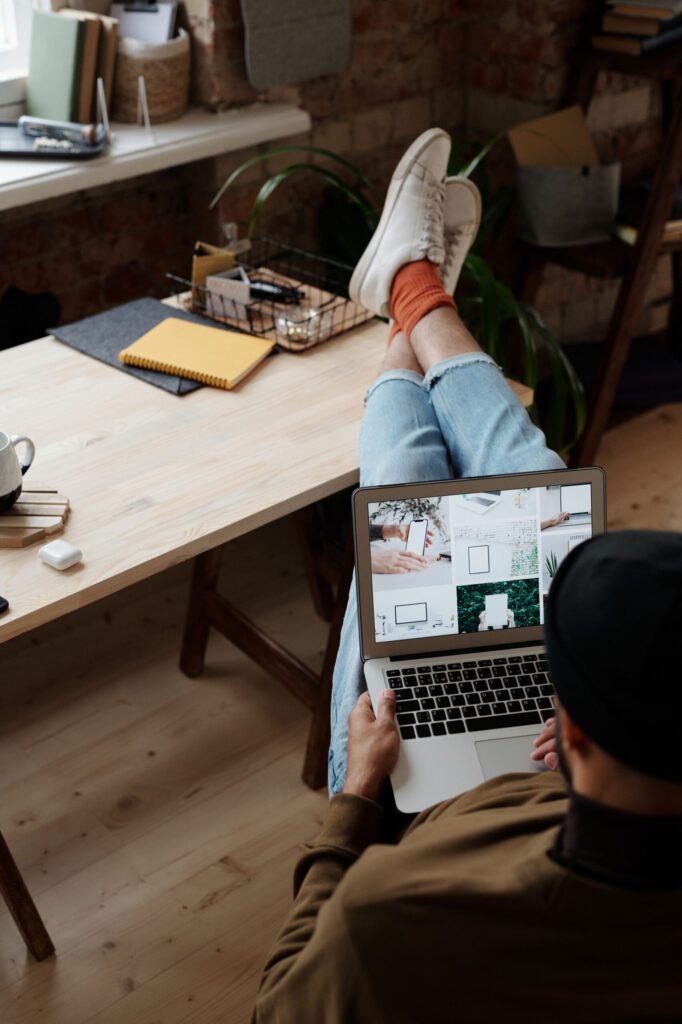 Casual work from home setup with a man using a laptop while seated indoors.