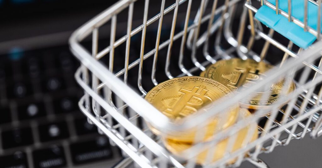 How The Money Actually Moves Close-up of bitcoins in a shopping cart placed on a laptop, symbolizing digital currency trading.