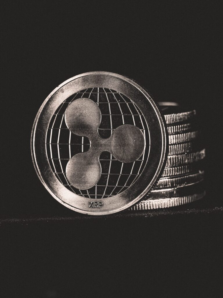 The Blockchain Mini Series - Part 3 Monochrome image of Ripple coins stacked vertically, symbolizing digital currency.