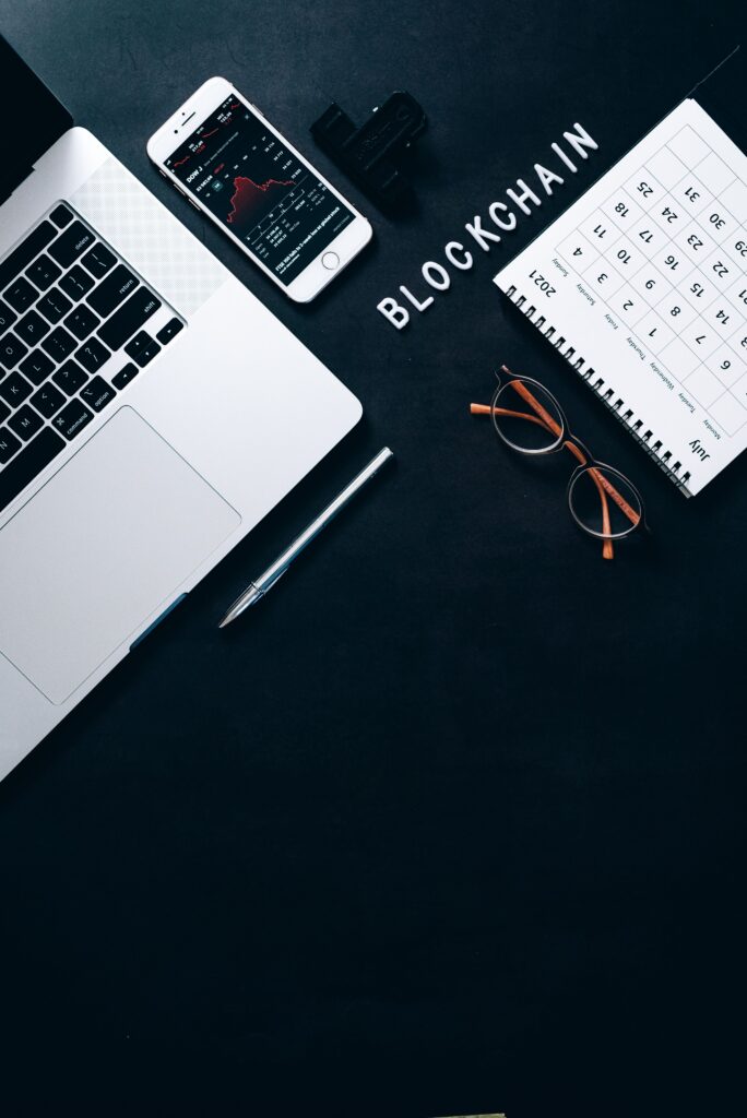Stylish workspace featuring blockchain concept with a laptop and smartphone on a dark background.