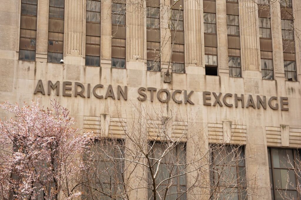 S&P Built a Crypto Index and Left Out Bitcoin Facade of the American Stock Exchange Building in New York City during spring with blooming trees.