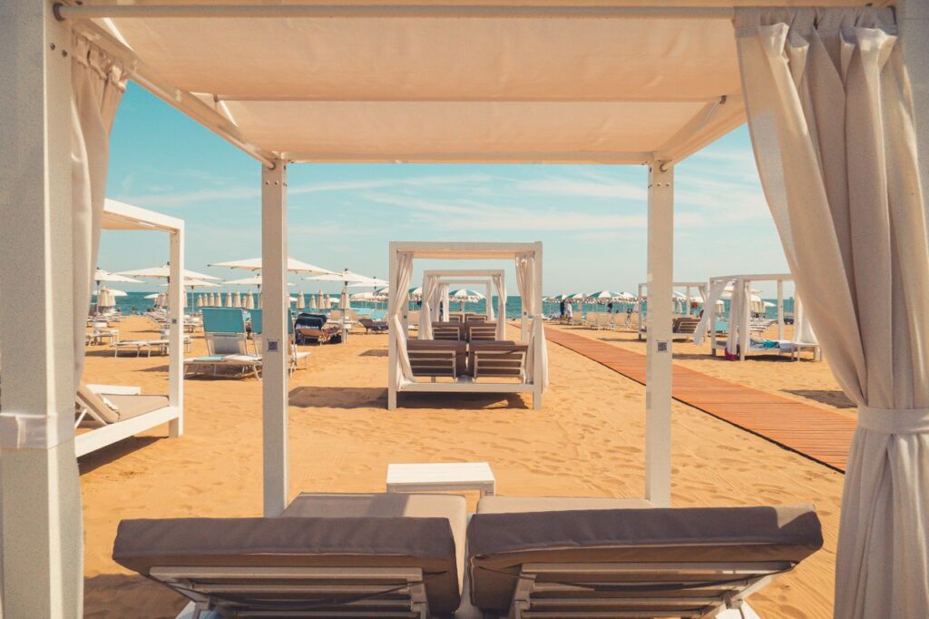 The New Luxury Is an Empty Beach Elegant cabanas set up on a sandy beach, perfect for a relaxing summer day by the sea.