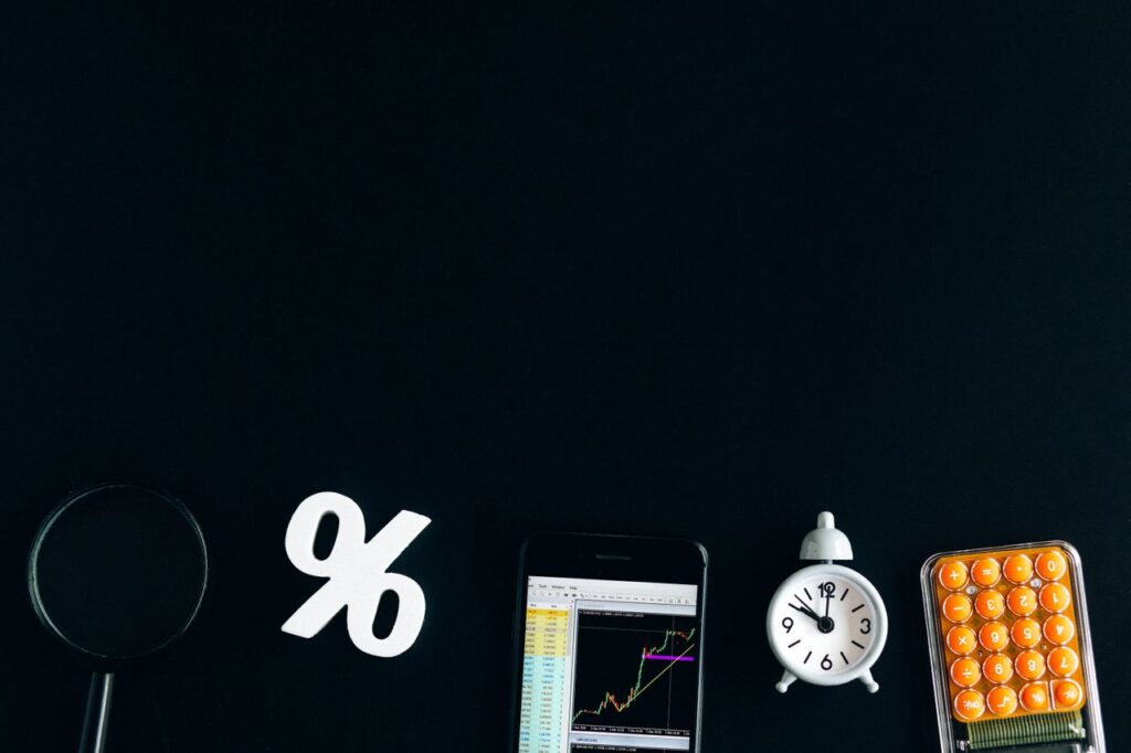 The Fed’s June Meeting: The Two-Trillion-Dollar Silence Flat lay of financial analysis tools including phone, clock, and calculator on black background.