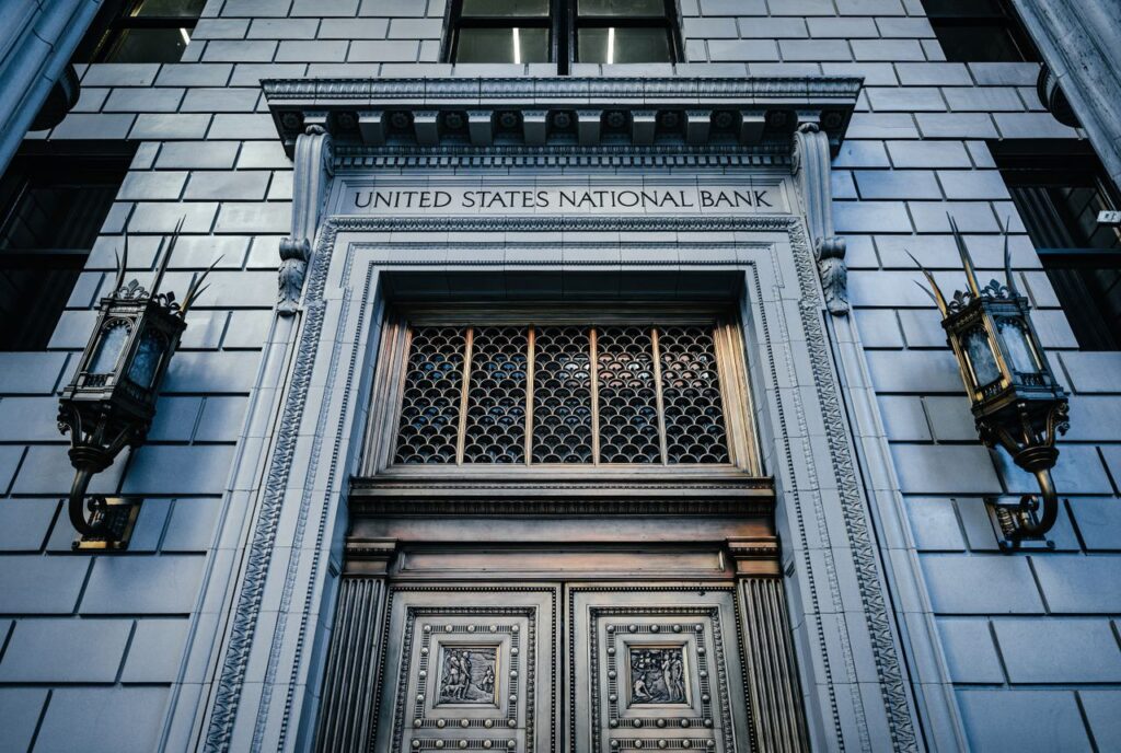 One Meeting Runs Your Whole Portfolio Now From below classic styled historic building of United States National Bank with wooden doors and vintage lanterns located in Portland