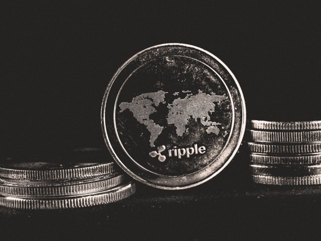 Ripple Is Winning. Its Token Is Not. A detailed shot of a Ripple coin with a world map design on a black background.