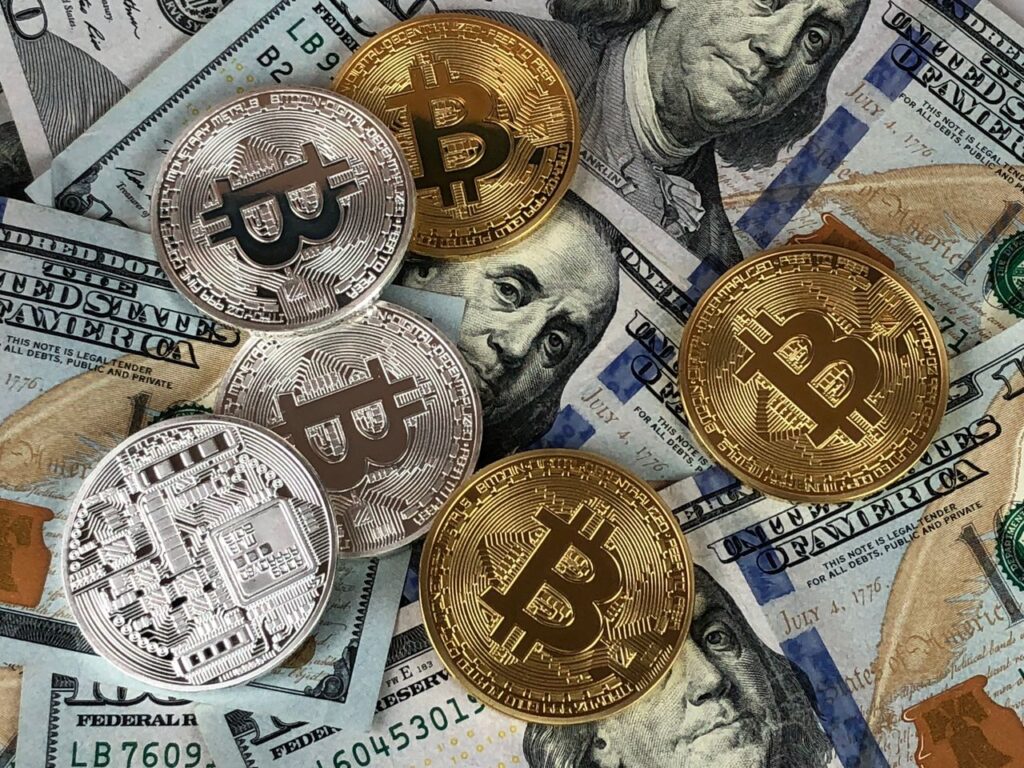 Trump Signs the Bitcoin Reserve Order: America Goes Digital Fort Knox Close-up of bitcoins and US dollar bills symbolizing modern finance and cryptocurrency.