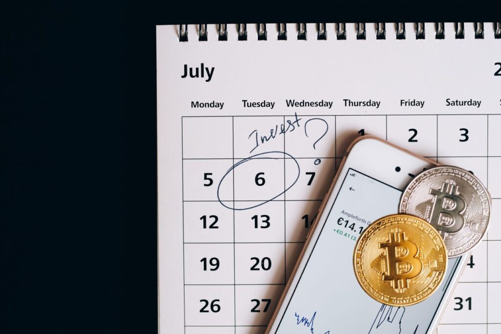 The Art of Dollar Cost Averaging Smartphone with bitcoins on calendar, marking investment date.