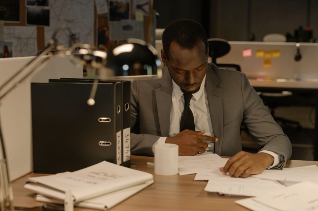 You Never Know Which Seed Will Take Businessman focused on paperwork at his desk in a modern office setting.