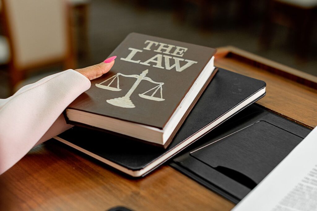 The GENIUS Act Becomes Law: America Gets Its First Stablecoin Framework Closeup image of a law book titled 'The Law' on a wooden desk with scales of justice.