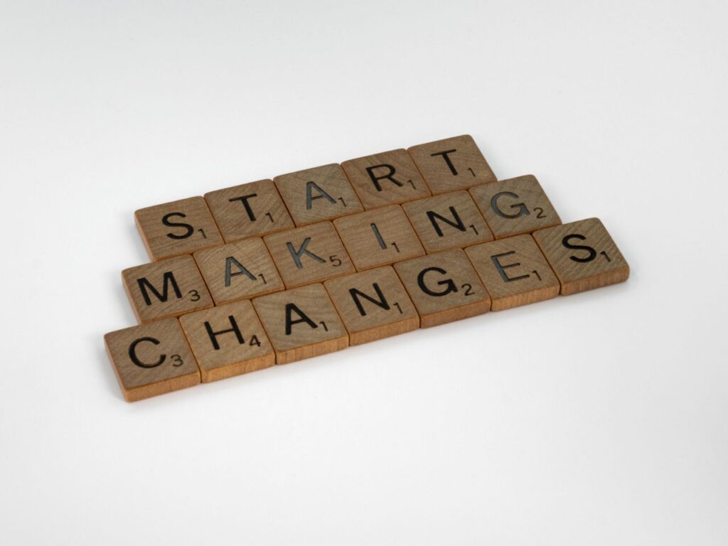 Why Change Never Sticks, and How to Make It Scrabble tiles on a white surface spelling 'Start Making Changes'.