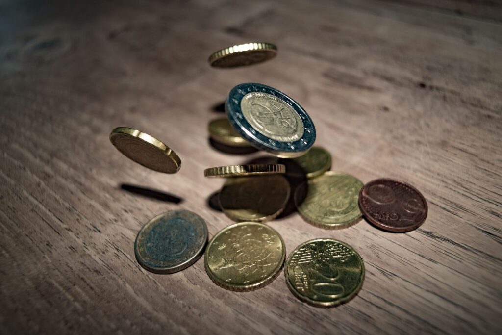 Stablecoins Are Crypto's Quiet Giant Capture of euro coins falling and spinning on a wooden table. Perfect depiction of finance and currency."