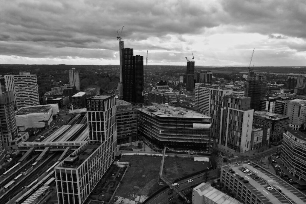 Giving Is Easy. Giving That Costs Is Not Monochrome aerial shot capturing the dramatic skyline of Croydon, London with modern architecture and urban landscapes.