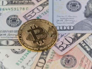 News Close-up of a Bitcoin coin on US dollar banknotes, symbolizing cryptocurrency and traditional finance.