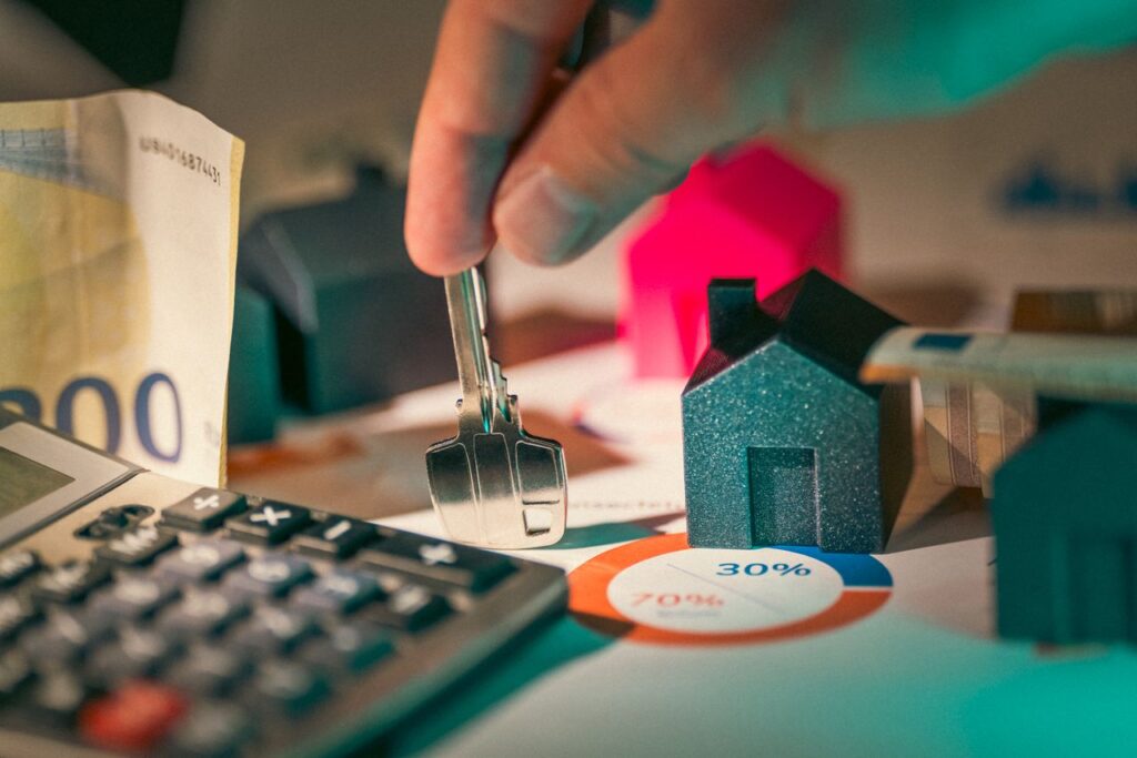 House Prices Barely Moved. Buying Got Harder A close-up of real estate financial planning with keys, calculator, and money.