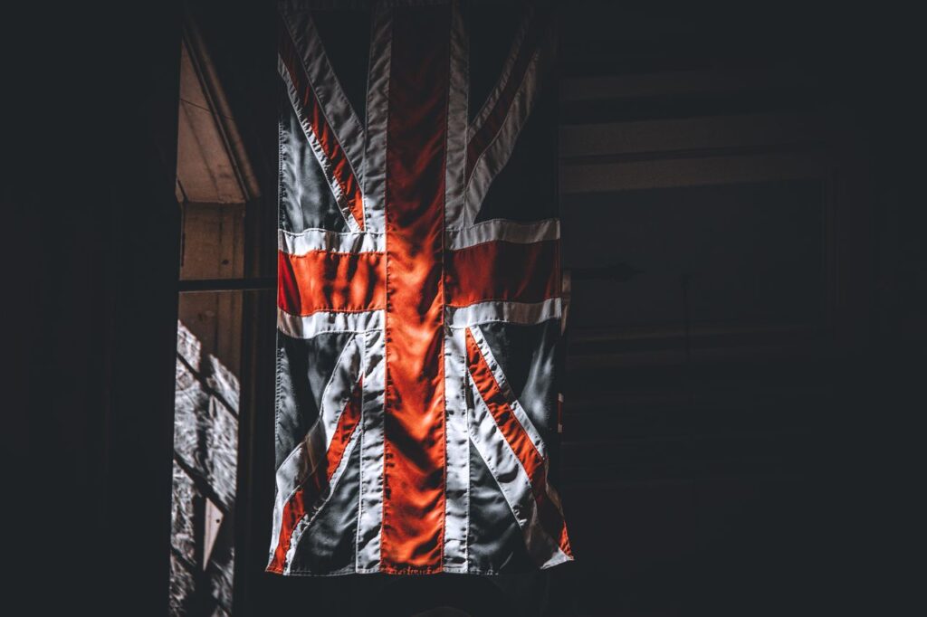 The Crypto Deadline Nobody Has Diarised A dramatic portrayal of the Union Jack flag inside a dimly lit room.