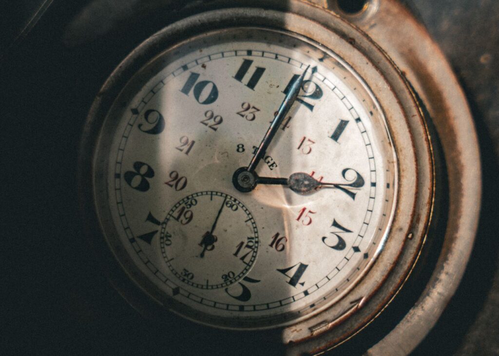 Time Has A Shape, And Mine Was Wrong Close-up of a vintage pocket watch with intricate clock hands casting shadows.