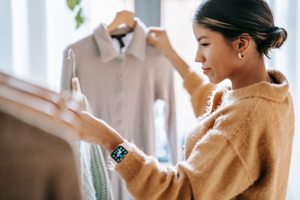 Clothes That Match the Life You Actually Live Crop focused ethnic female in casual clothes choosing apparel while standing near rack in boutique