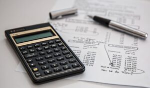 Articles Close-up of financial documents with calculator and pen, ideal for business management themes.