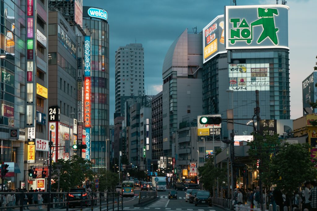Japan Raised Rates, and the Yen Still Fell Evening view of a bustling urban street in Tokyo, showcasing vibrant city lights and bustling activity.
