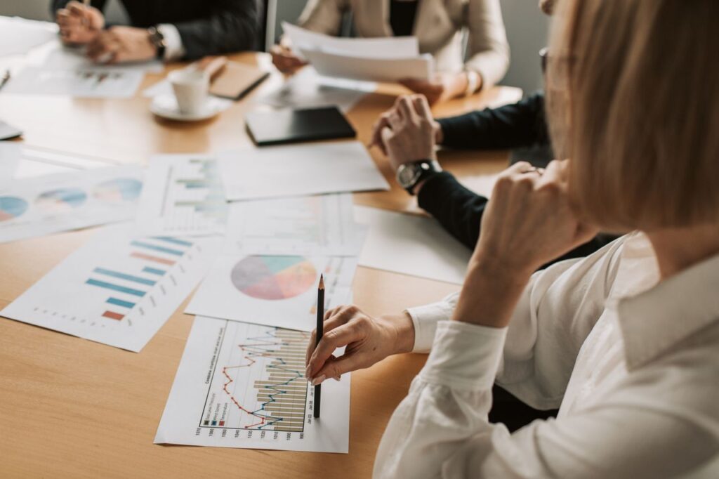 The Jobs Report That Undid the Fed's Good Mood Business professionals reviewing charts and graphs during a meeting in office setting.