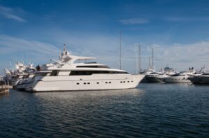 A serene marina scene featuring luxury yachts docked under a clear blue sky.