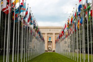 Articles From below of various flags on flagpoles located in green park in front of entrance to the UN headquarters in Geneva