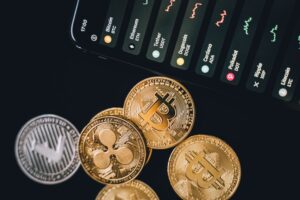 Articles Close-up view of various cryptocurrency coins with a digital market display in the background.